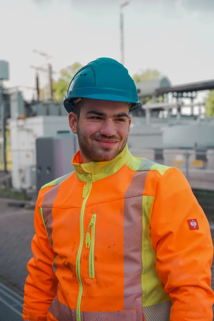 Bauhelfer in Warnschutzkleidung mit Schutzhelm auf einer Baustelle