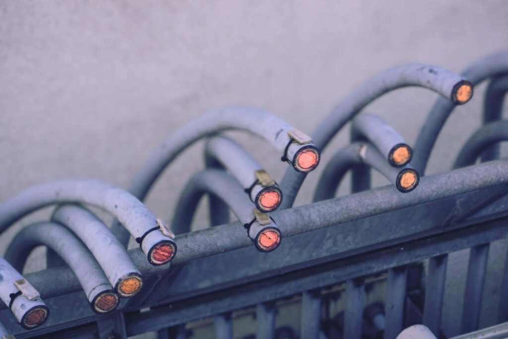 Abgeschnittene, mehradrige Stromkabel in einer Metallführung, Enden mit Kupferleitern sichtbar.