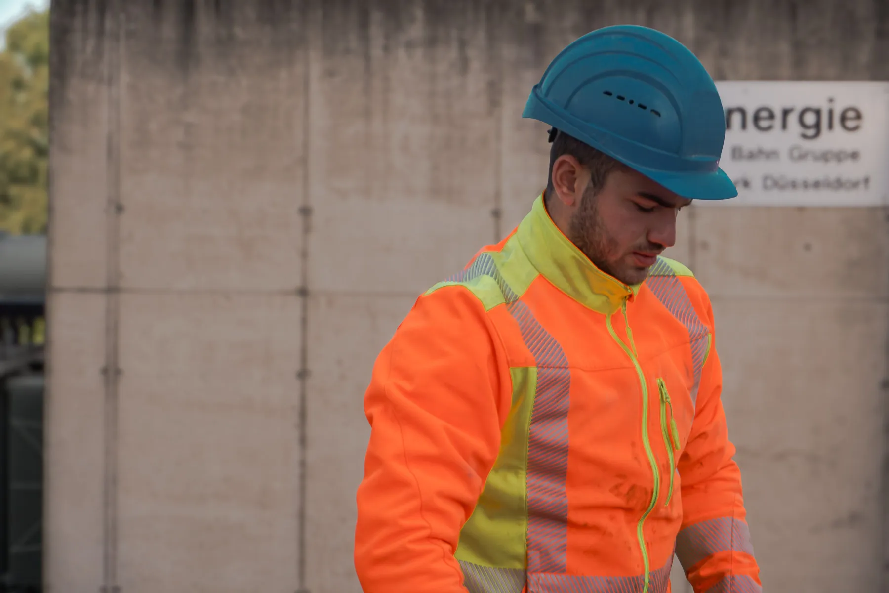 Teammitglied in Warnschutzkleidung mit Schutzhelm auf der Baustelle