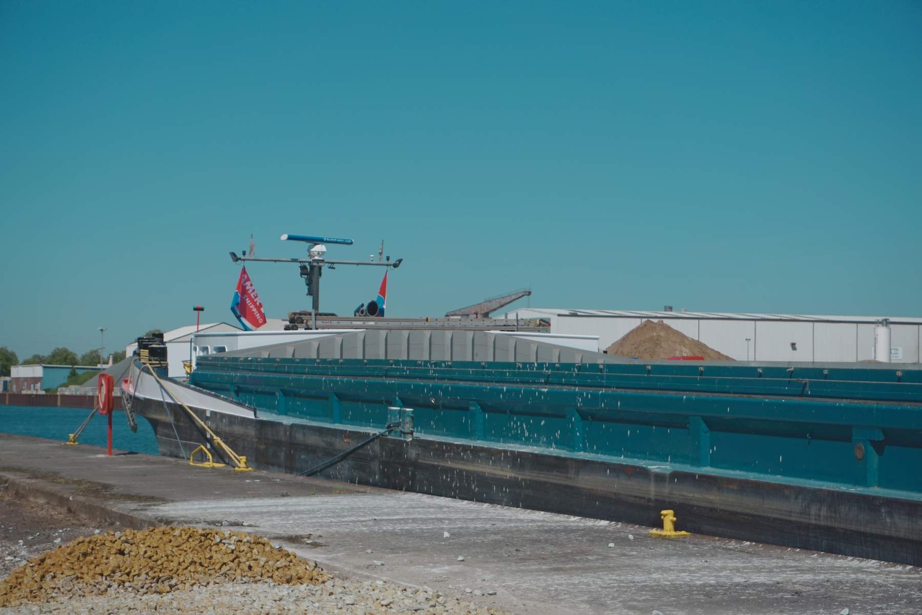Binnenschiff am Kai, vorbereitet für Schüttgutumschlag
