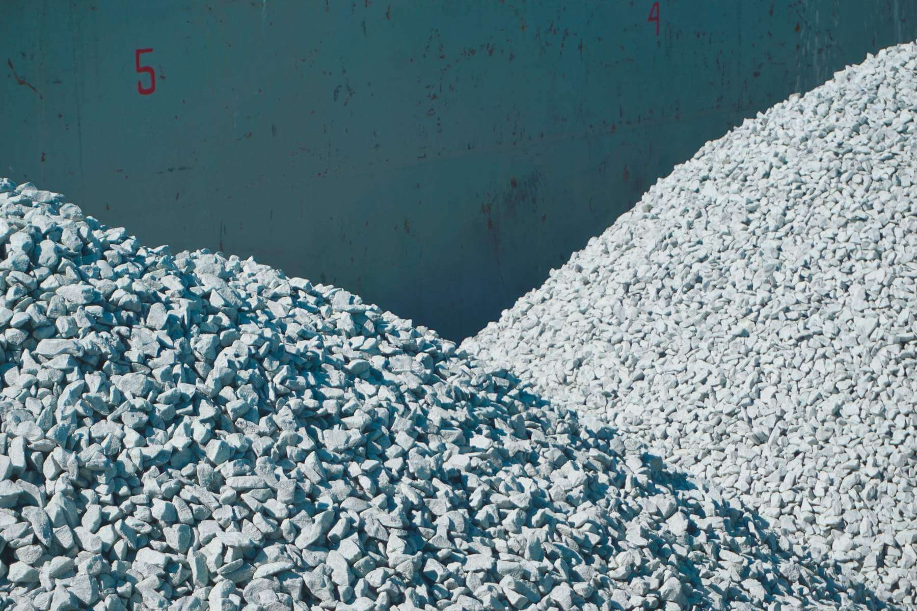 Zwei Schotterhügel im Laderaum eines Binnenschiffs, Markierungen an der Bordwand