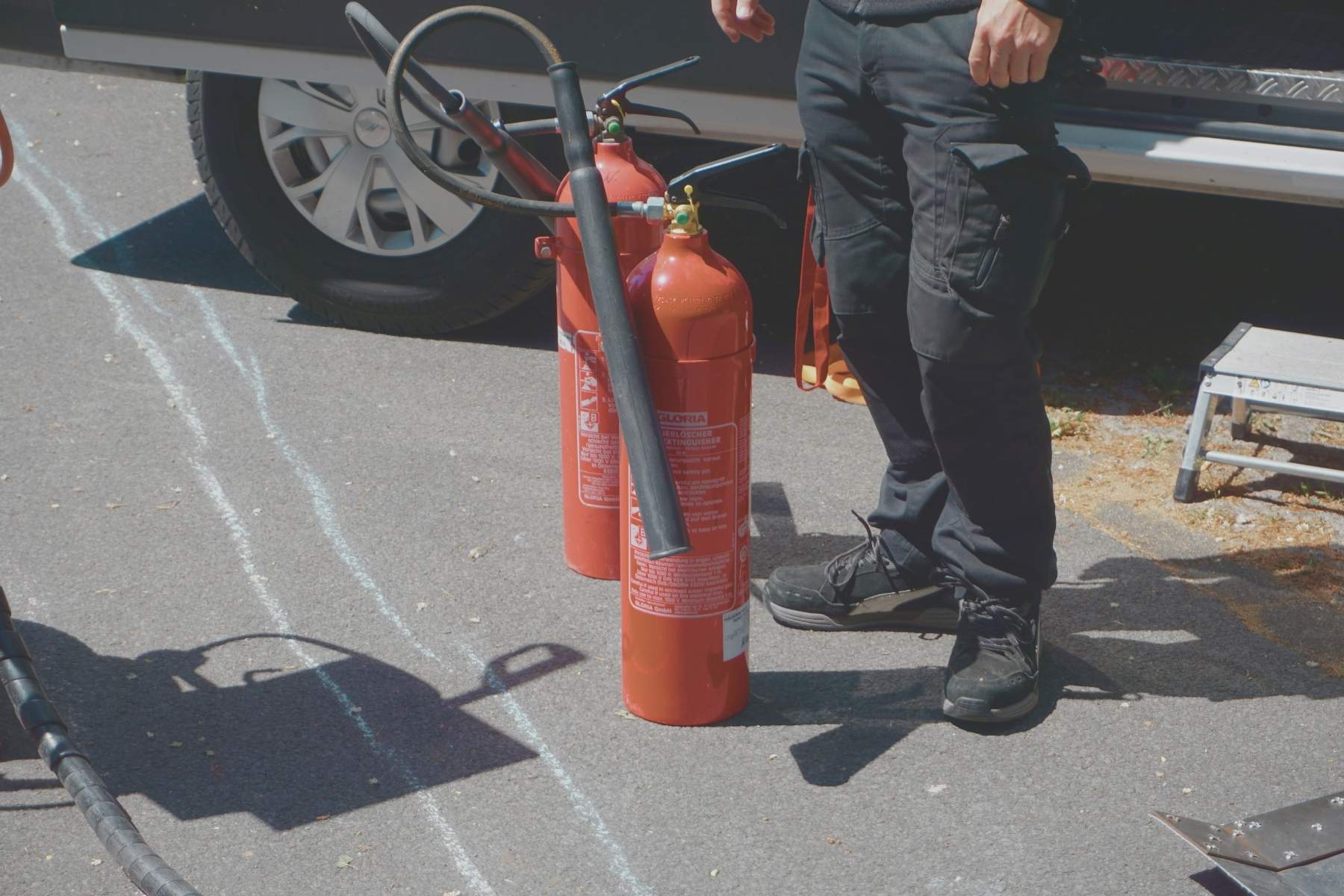Zwei Feuerlöscher stehen in einer markierten Übungszone auf dem Gelände.