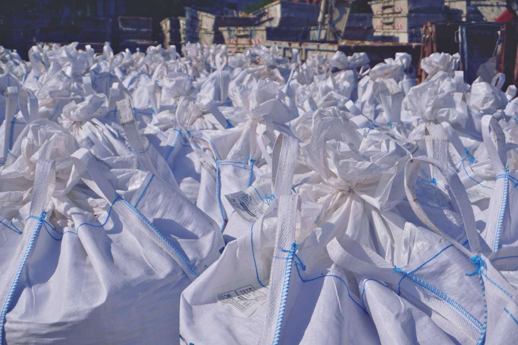 Viele verschlossene BigBags stehen dicht an dicht auf einem Betriebshof