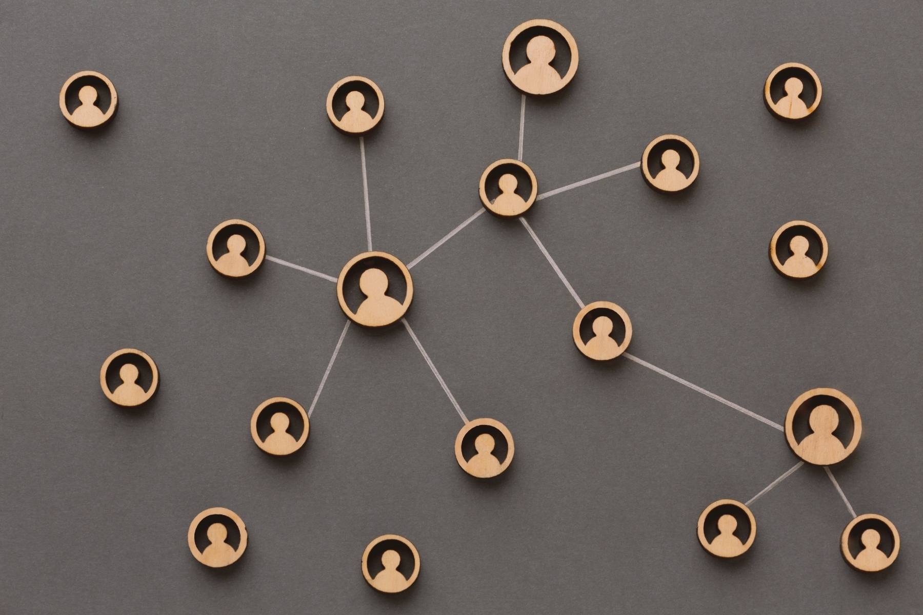 Holzwürfel mit Personen-Symbolen, durch Linien sternförmig verbunden