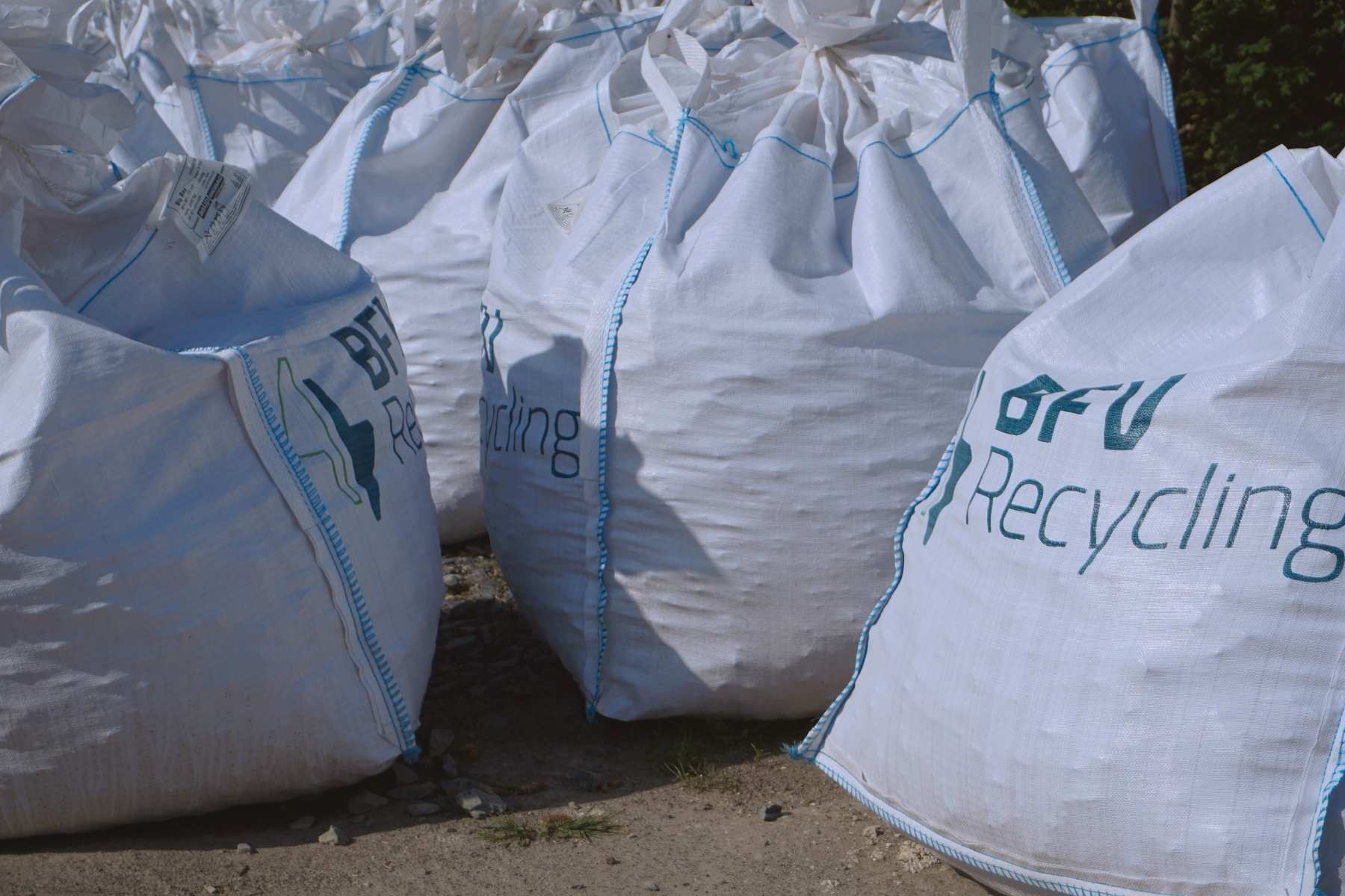 Viele verschlossene BigBags stehen dicht an dicht auf einem Betriebshof