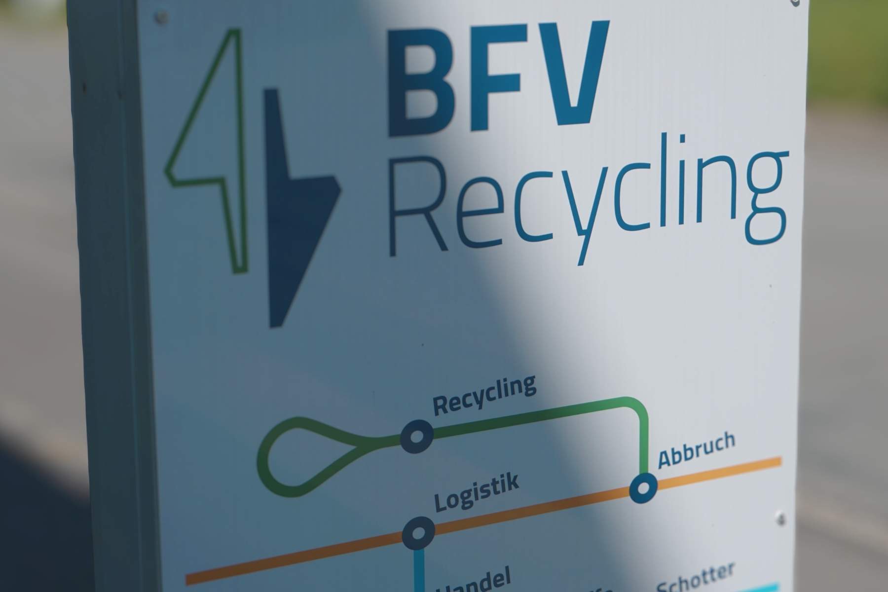 Nahaufnahme eines BFV Recycling Firmenschilds mit grafischer Übersicht zu Recycling, Logistik und Abbruch.
