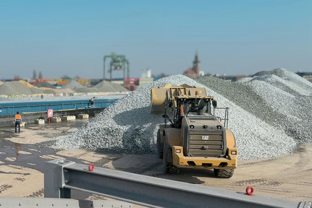 Bagger entlädt Schiff mit Neuschotter aus Dotmund.