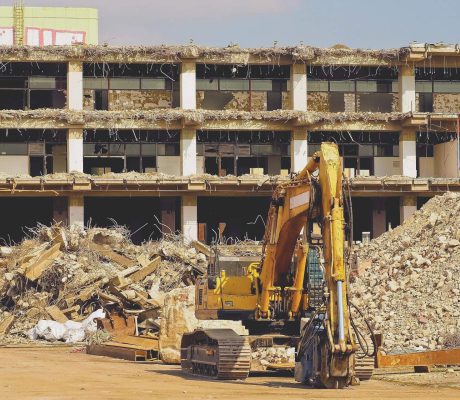 Bagger beim selektiven Rückbau einer Industriehalle – sortenreiner Abbruch mit Beton- und Ziegelhaufen für Recycling
